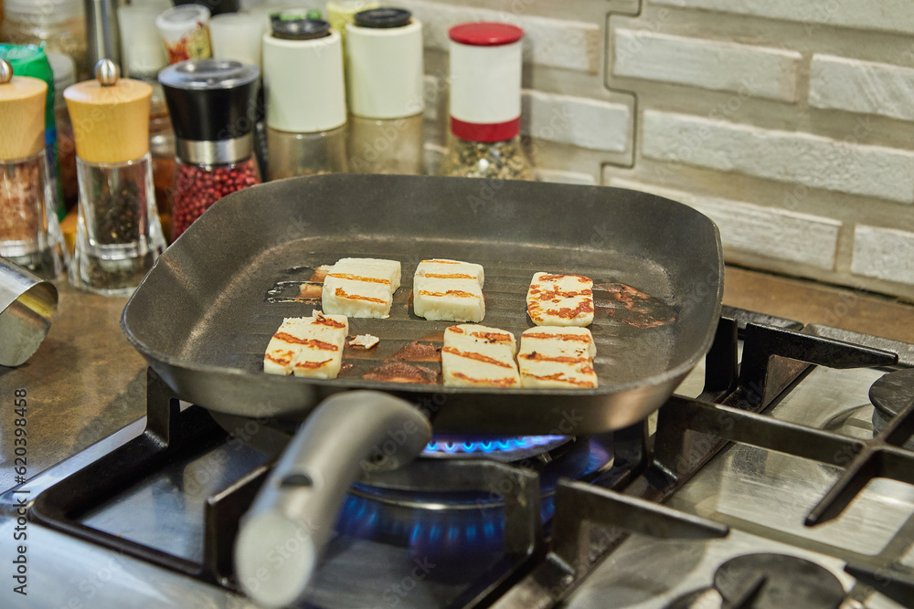 Canvas Prints Halloumi cheese is fried on ribbed pan over fire on gas stove