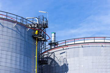 Oil storage tanks with blue sky background, Industrial tanks for petrol and oil, White fuel storage tank against blue sky.