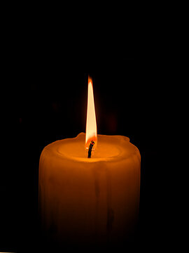 Only light candle burning brightly in the black background