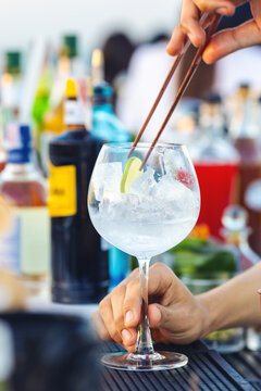 Close-up bartender hand making cocktail at rooftop bar