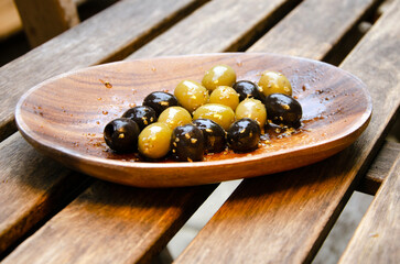 Wooden bowl with green and black olives