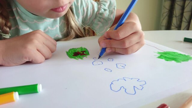 Cute child drawing a picture with colored felt-tip pens. Concept of education