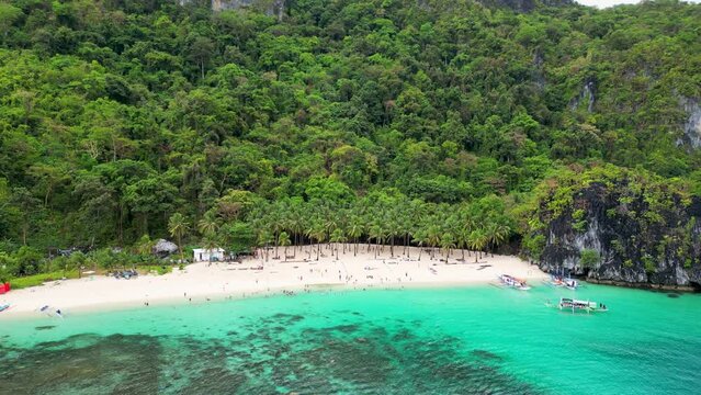 El nido Palawan region beach with coconut palm trees and paraw canoe, aerial orbit
