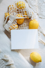 Mockup postcard or invitation or card on the background of Citrus lemon in a wicker cotton bag on a...