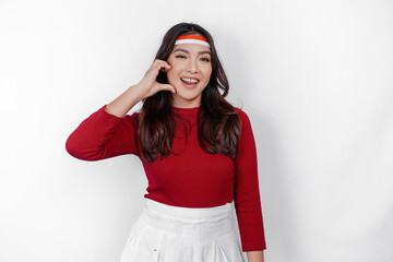 A young Asian woman wearing a red top feels nationalism, shapes heart gesture expresses her love...