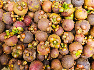 Top view Pile of Mangosteens in a supermarket local market in Thailand, Bunch of organic mangosteen ready to eat. Fresh mangosteen background