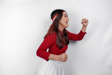 A young Asian woman with a happy successful expression wearing red top and flag headband isolated...