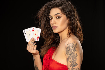 Confident young brunette holding pair of aces with winning look