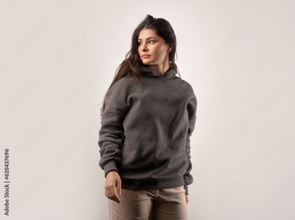 Wall mural Woman wears a black hoodie mock-up. Streetwear clothing branding. Logo on shirt template copy space.