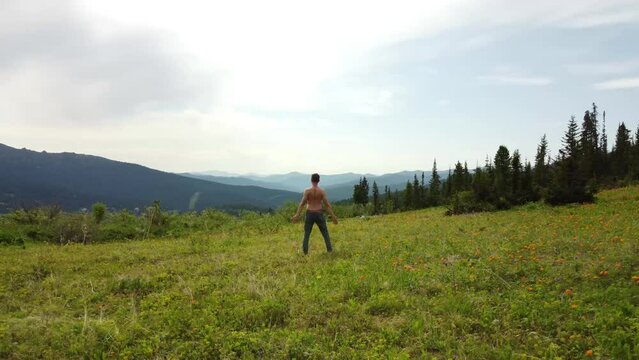 Man doing yoga outdoors, at mountains background. 