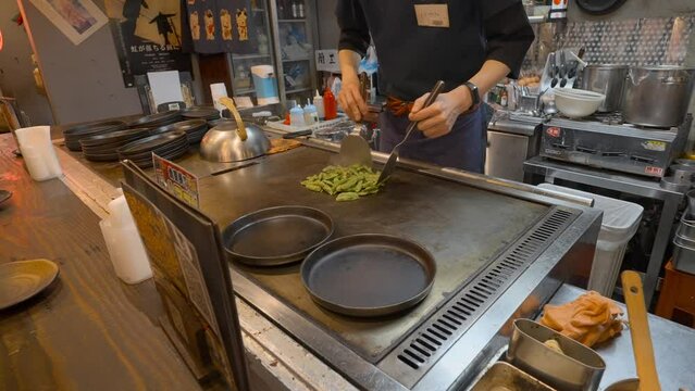 Japanese chef grilling Edamame. Slowed to half speed