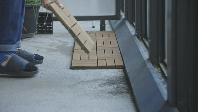 Crop View Of A Person Putting Interlocking Deck Tiles On A Veranda. Close Up
