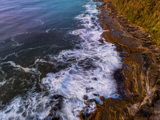 Aerial sunrise over the sea from the headland