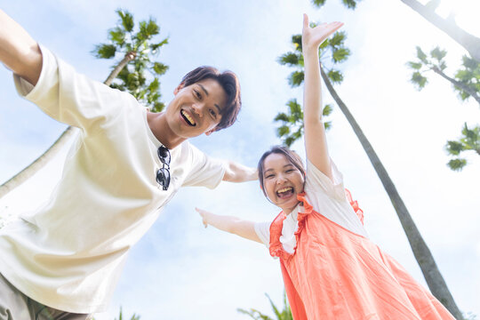 青空をバックにはしゃぐ男女