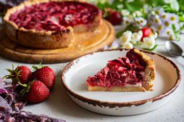 Berry dessert for the whole family: sweet strawberry pie. Strawberry tart on a large plate and a piece of pie on a plate. Strawberry dessert for breakfast. A piece of strawberry pie on a plate. Close