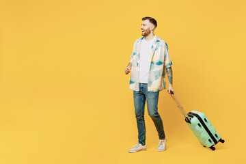 Traveler profile man wearing summer casual clothes hold suitcase strolling isolated on plain yellow background Tourist travel abroad in free spare time rest getaway. Air flight trip journey concept.