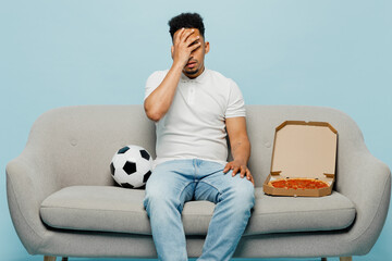 Full body dissatisfied young man fan wear t-shirt cheer up support football sport team hold soccer...