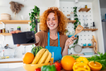 In a modern kitchen, woman takes a selfie while cooking. With a radiant smile and culinary delights...