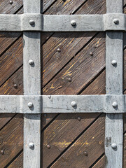 fragment of wooden gate and iron strips, part of ancient castle