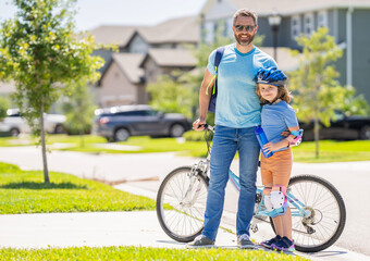 Obraz premium father teaching his son to ride a bicycle, copy space. father and son outdoor. father and son enjoying a bicycle ride together. active son and father duo cycling through scenic countryside on bicycle