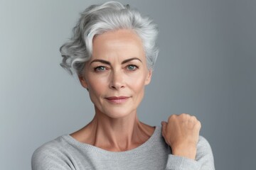 Beautiful gorgeous 50s mid aged mature woman looking at camera isolated on white. Mature old lady close up portrait. Healthy face skin care beauty, middle age skincare cosmetics, cosmetology concept. - obrazy, fototapety, plakaty