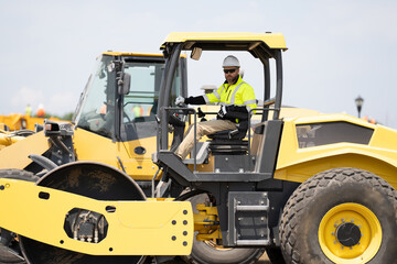 busy worker man on construction equipment. construction man worker driving heavy machinery for...