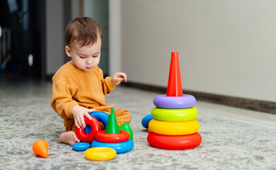 Adorable young kid with fun activities. Happy little boy playing with colorful toys.
