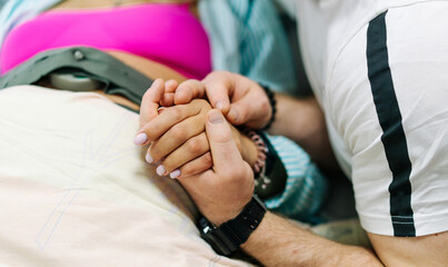 Female hands and her husband holding. Man holding hands pregnant woman.