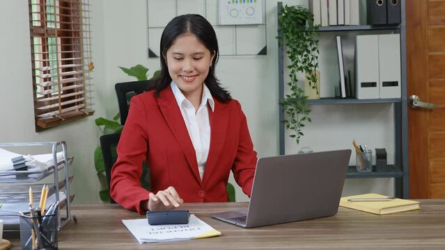 financial, Planning, Marketing and Accounting, portrait of Asian employee checking financial statements using computer laptop, documents and calculators at work.