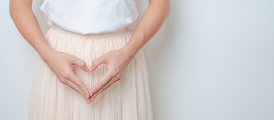 Woman hand heart shape over abdomen. Ovarian and Cervical cancer, Endometriosis, Hysterectomy,...