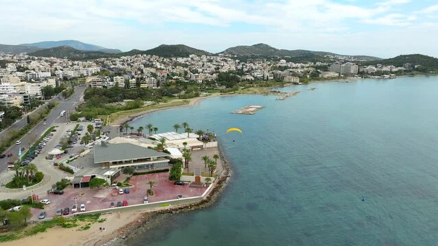 Aerial view of Powered Paragliding flyover scenic beach coastline in Glyfada. Athens