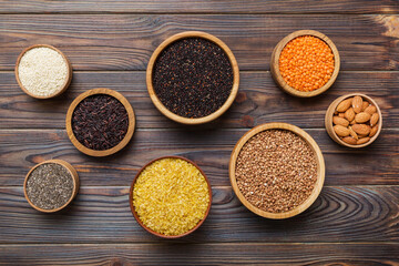 Various superfoods in smal bowl on colored background. Superfood as rice, chia, quinoa, lentils, nuts, sesame seeds, almonds. top view copy space