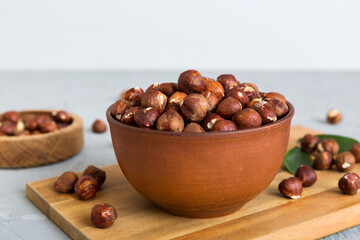 Wooden bowl full of hazelnuts on table background. Healthy eating concept. Super foods