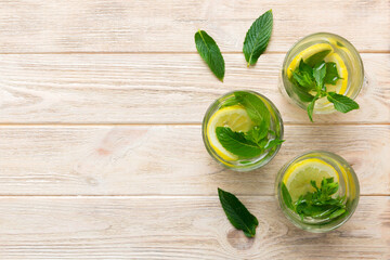 Caipirinha, Mojito cocktail, vodka or soda drink with lime, mint and straw on table background. Refreshing beverage with mint and lime in glass top view flat lay