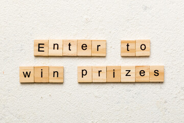 Enter to win prizes word written on wood block. Enter to win prizes text on cement table for your desing, Top view concept