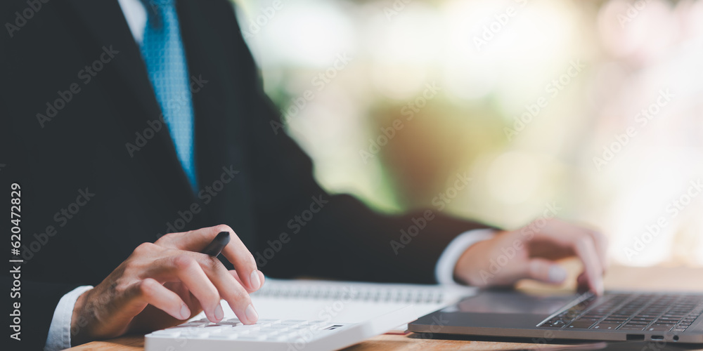 Poster Businessman using a calculator to calculate numbers ,profit and loss statement review of company performance , effective tax deduction planning for individuals and companies paying tax rates