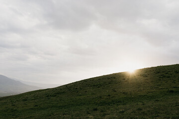 The sunlight breaks through the clouds on a summer evening, creating a beautiful sunset