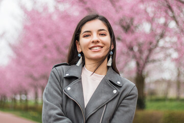 Portrait of independent multi-ethnic Turkish woman 25s with stylish make-up and casual clothes smiling in the street