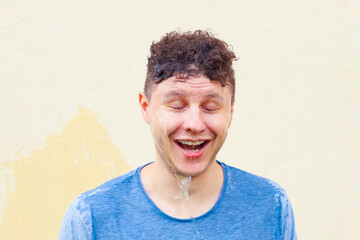 Shocked mid adult european caucasian white male man with open mouth and closed eyes and water...