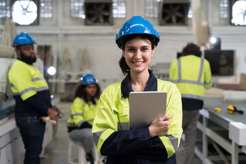 Portrait of happy smiling female engineer worker working in industry factory. Young female...