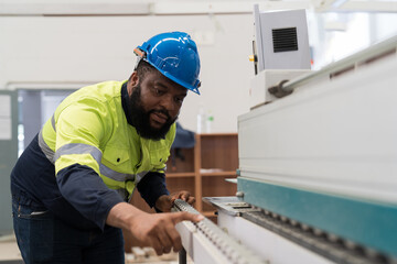 Male engineer worker checking conveyor belt machine at the industry factory. Male technician wear safety uniform working maintaining machine in the factory