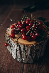 Cherries on a wooden stand. Brown background. Summer atmosphere.  Vitamins. Organic food. Red food. Juicy dessert.