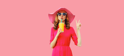 Summer portrait of beautiful young woman drinking fresh juice wearing straw hat, pink dress on background - Powered by Adobe