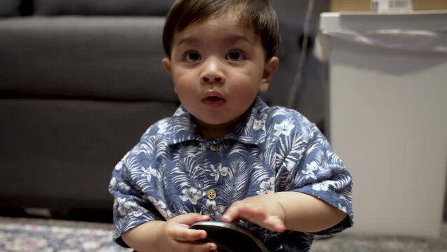 Indian baby Sat On Floor Holding Computer Mouse. Slow Motion Shot