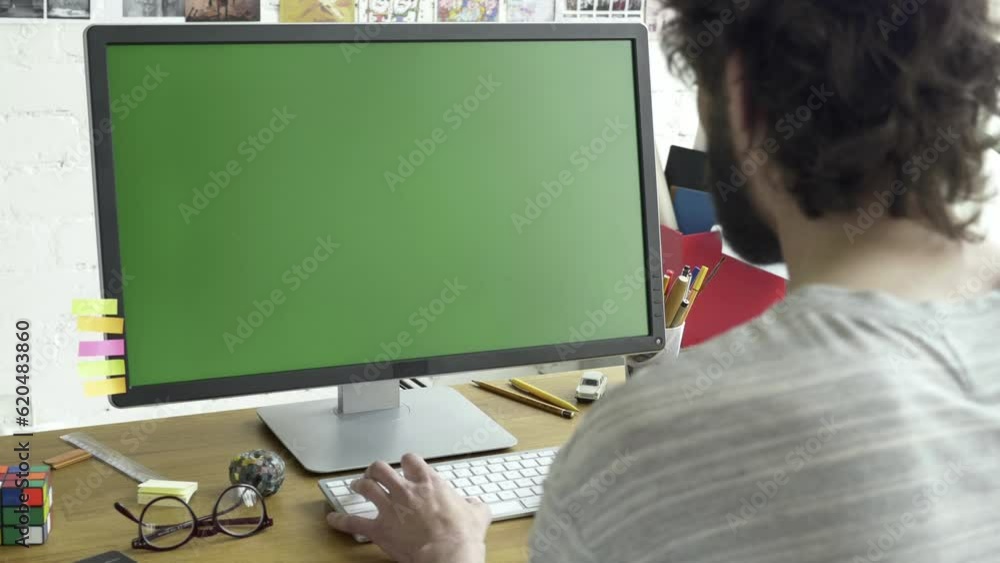 Poster green screen computer display placed on wooden table in working room. adult caucasian male working i