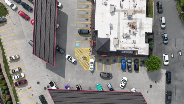 Cars line up waiting to refuel at gas station during fuel shortage. Descending aerial time lapse above gasoline station in USA.