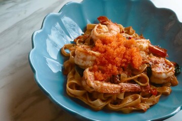 closeup spicy fried shrimp pasta on top with mentaiko