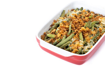 A traditional green bean casserole topped with French Fried Onions and cream of mushroom isolated on white background. Copy space