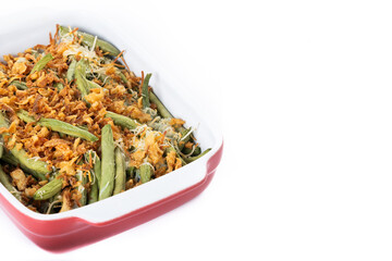 A traditional green bean casserole topped with French Fried Onions and cream of mushroom isolated on white background. Copy space