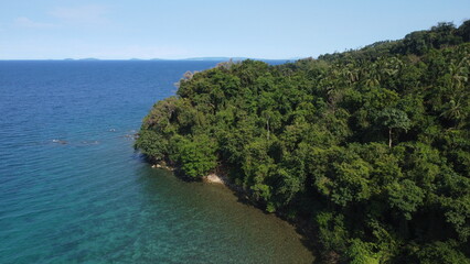 Aerial view of the coast of the island and the sea. The shore of a tropical island covered with tropical rainforest.
